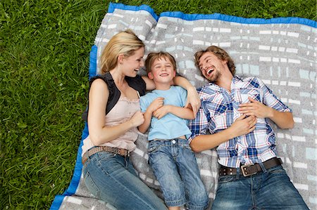 family and pets - Happy family lying on blanket in meadow Stock Photo - Premium Royalty-Free, Code: 628-07072289