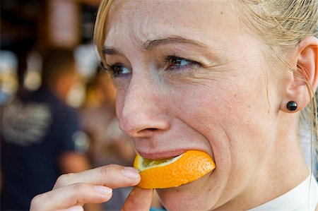 Woman biting on orange slice on the Oktoberfest in Munich, Bavaria, Germany Stock Photo - Premium Royalty-Free, Code: 628-07072374