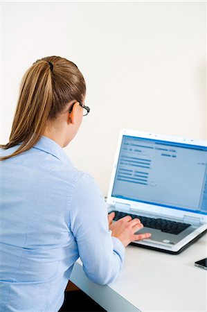 seated girl back view - Businesswoman using laptop at desk Stock Photo - Premium Royalty-Free, Code: 628-07072452