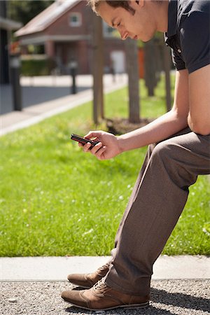 simsearch:628-07072884,k - Young man text messaging outdoors Stock Photo - Premium Royalty-Free, Code: 628-07072492