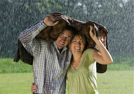 rain shelter - Couple standing underneath a jacket in rain Stock Photo - Premium Royalty-Free, Code: 628-07072513