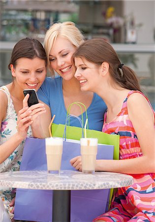 Three happy young women with  cell phone and shopping bags Stock Photo - Premium Royalty-Free, Code: 628-07072546