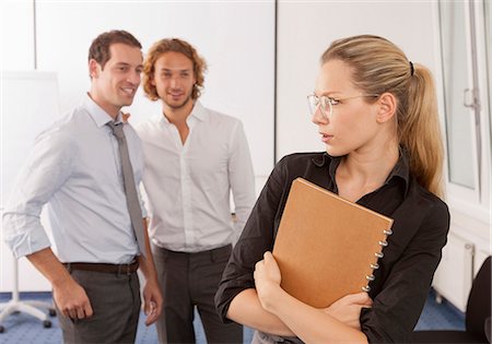 Two businessmen harassing young woman in office Stock Photo - Premium Royalty-Free, Code: 628-07072541