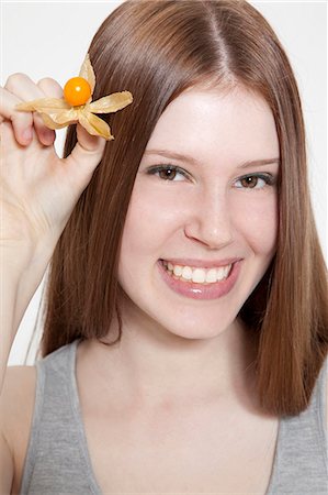 simsearch:628-07072621,k - Brunette young woman holding cape gooseberry Stock Photo - Premium Royalty-Free, Code: 628-07072560