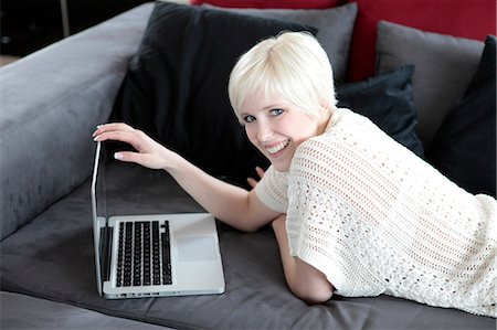 simsearch:628-07072884,k - Smiling young woman using laptop on couch Stock Photo - Premium Royalty-Free, Code: 628-07072693