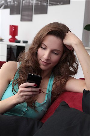 simsearch:628-07072884,k - Brunette young woman using cell phone on couch Stock Photo - Premium Royalty-Free, Code: 628-07072704
