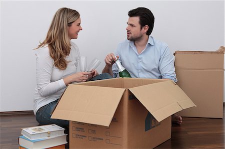 pictures man opening bottle - Couple celebrating with champagne amidst moving boxes Stock Photo - Premium Royalty-Free, Code: 628-07072738