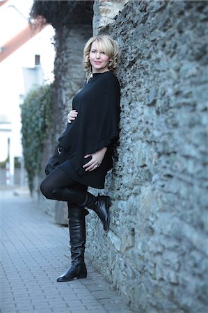 portrait of pregnant woman - Pregnant woman leaning against stone wall Stock Photo - Premium Royalty-Free, Code: 628-07072879