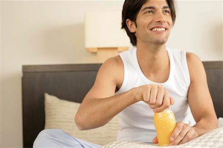 pictures man opening bottle - Young man opening a bottle of juice Stock Photo - Premium Royalty-Free, Code: 628-00918677