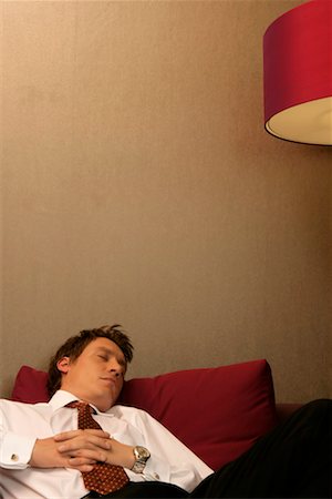 Businessman snoozing on a sofa Stock Photo - Premium Royalty-Free, Code: 628-00918743