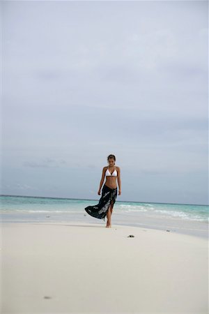 Jeune fille portant des bikini et paréo, marchant le long de la plage Photographie de stock - Premium Libres de Droits, Code: 628-00919174