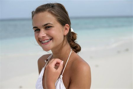 simsearch:628-00919176,k - Young girl at the beach smiling at camera, having brace Stock Photo - Premium Royalty-Free, Code: 628-00919210