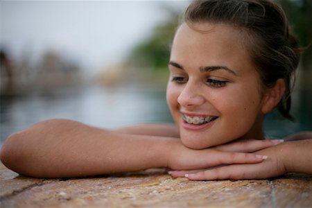 simsearch:628-00919176,k - Young smiling girl with brace looking out of a swimming pool Stock Photo - Premium Royalty-Free, Code: 628-00919235