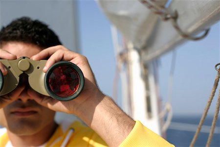Man looking through binoculars Stock Photo - Premium Royalty-Free, Code: 628-00919939