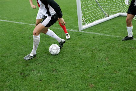 Soccer players in action in front of a goal Stock Photo - Premium Royalty-Free, Code: 628-00920187