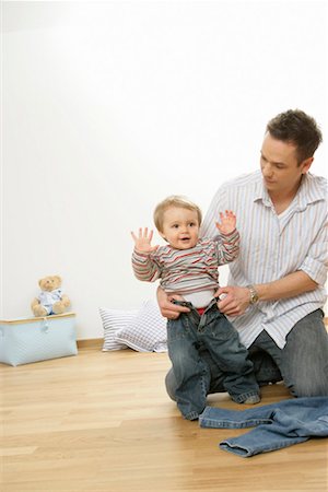 Father putting on  son's jeans Stock Photo - Premium Royalty-Free, Code: 628-00920364