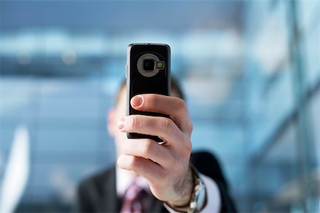 Businessman holding mobile phone to the camera Stock Photo - Premium Royalty-Free, Code: 628-01278286