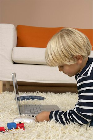 plugging in - Boy (4-5 Years) lying on floor and using a laptop Stock Photo - Premium Royalty-Free, Code: 628-01278879