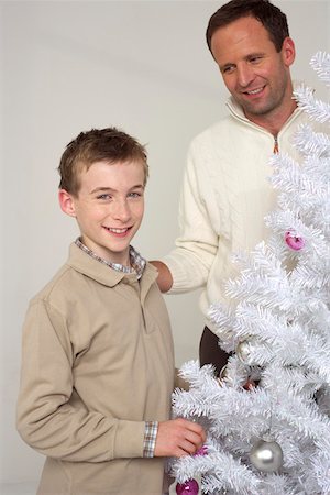 father christmas family portrait - Father and son next to a white Christmas tree Stock Photo - Premium Royalty-Free, Code: 628-01279278