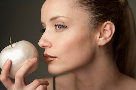 Young woman holding an apple Stock Photo - Premium Royalty-Free, Code: 628-01495216