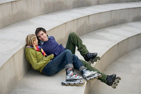 Young couple wearing Inline skates sitting on a staircase Stock Photo - Premium Royalty-Free, Code: 628-01495308