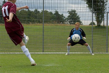 soccer player kicking ball into the goal - Soccer game Stock Photo - Premium Royalty-Free, Code: 628-01586551