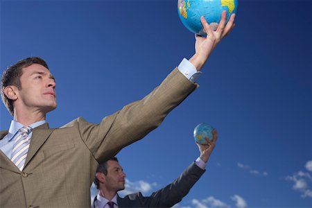 Two businessmen holding globes up Stock Photo - Premium Royalty-Free, Code: 628-01639100