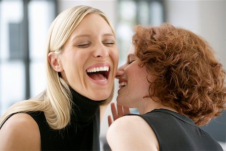 Two laughing young women whispering Stock Photo - Premium Royalty-Free, Code: 628-01712019