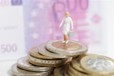 Female doctor figurine on a stack of coins Stock Photo - Premium Royalty-Free, Code: 628-01712340