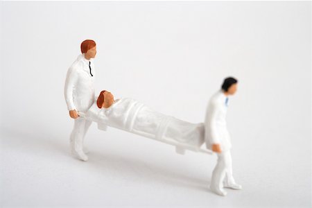 Figurines of doctors carrying a stretcher Stock Photo - Premium Royalty-Free, Code: 628-01712353