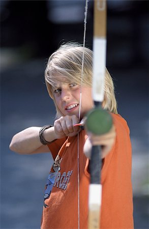 Blonde Boy targeting at the Spectator with a Toydart on a Bow - Archery - Weapon - Leisure Time Stock Photo - Premium Royalty-Free, Code: 628-02615676