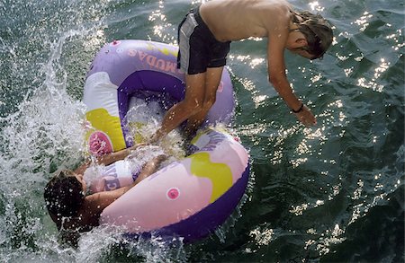 Two Boys jumping out of a Rubber Dinghy at the same Time - Fun - Youth - Lake Stock Photo - Premium Royalty-Free, Code: 628-02615694