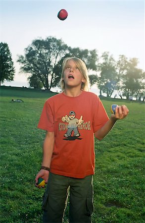 picture of orange and green object - Blonde boy juggling with three Balls - Legerdemain - Leisure Time - Meadow Stock Photo - Premium Royalty-Free, Code: 628-02615721