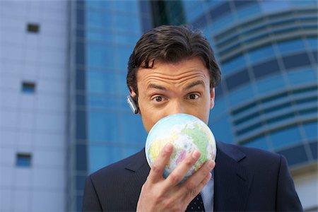 Businessman covering his face with an earth ball Stock Photo - Premium Royalty-Free, Code: 628-02954144