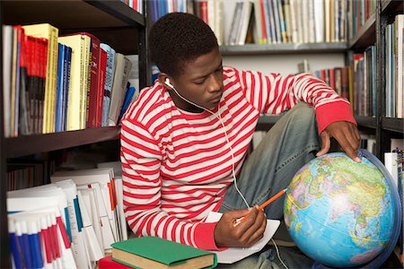 Student with earphones looking at a globe Stock Photo - Premium Royalty-Free, Code: 628-02954242