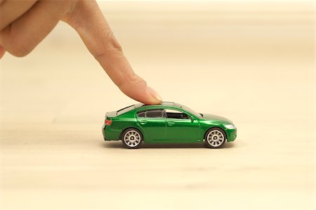 Finger pushing green toy car Stock Photo - Premium Royalty-Free, Code: 628-02953541