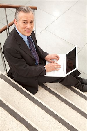 revolve - Businessman using laptop on stairs, Munich, Bavaria, Germany Stock Photo - Premium Royalty-Free, Code: 628-02953590