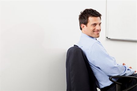 revolve - Smiling businessman in office, Munich, Bavaria, Germany Stock Photo - Premium Royalty-Free, Code: 628-02953635