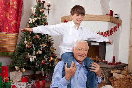 Grandfather carrying boy on shoulders at Christmas tree Stock Photo - Premium Royalty-Free, Code: 628-02953674