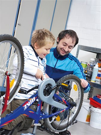 Father and son repairing bicycle Stock Photo - Premium Royalty-Free, Code: 628-02953965