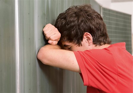 Depressed schoolboy leaning against blackboard Stock Photo - Premium Royalty-Free, Code: 628-03058843