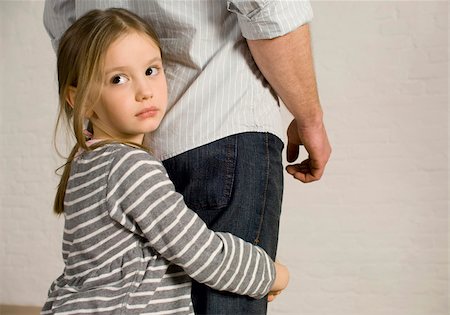 Girl clutching legs of her father Stock Photo - Premium Royalty-Free, Code: 628-03058874