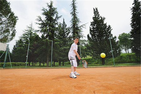 determined youth sports - Young Boy Playing Tennis Foto de stock - Sin royalties Premium, Código: 622-05390881