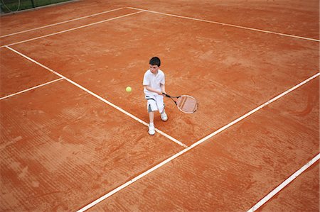 determined youth sports - Young Boy Hitting Backhand Shot Stock Photo - Premium Royalty-Free, Code: 622-05390928