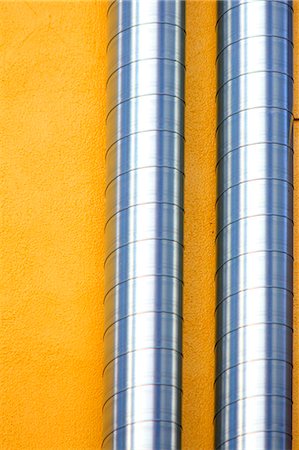 pipe (industry) - Two ventilation ducts crawling on a yellow wall Stock Photo - Premium Royalty-Free, Code: 622-06397991