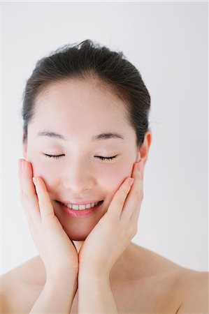 east asian beauty - Young woman with no make-up smiling with closed eyes Stock Photo - Premium Royalty-Free, Code: 622-06964255