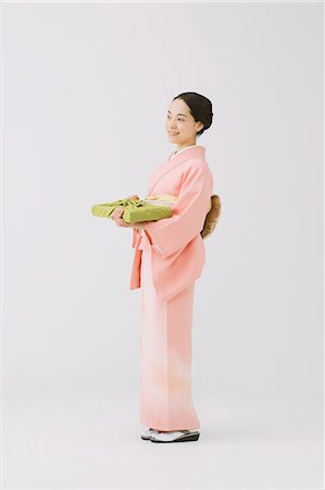 Young Japanese woman in a traditional kimono against white background Stock Photo - Premium Royalty-Free, Code: 622-07743558