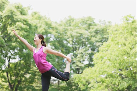 saving (keeping) - Young Japanese girl stretching in the park Stock Photo - Premium Royalty-Free, Code: 622-07760594