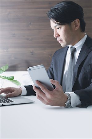 simsearch:622-08519684,k - Japanese businessman working with large display smartphone Stock Photo - Premium Royalty-Free, Code: 622-08122873