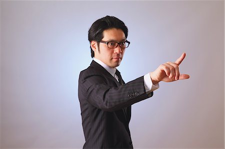 Japanese businessman using virtual reality device Stock Photo - Premium Royalty-Free, Code: 622-08123094